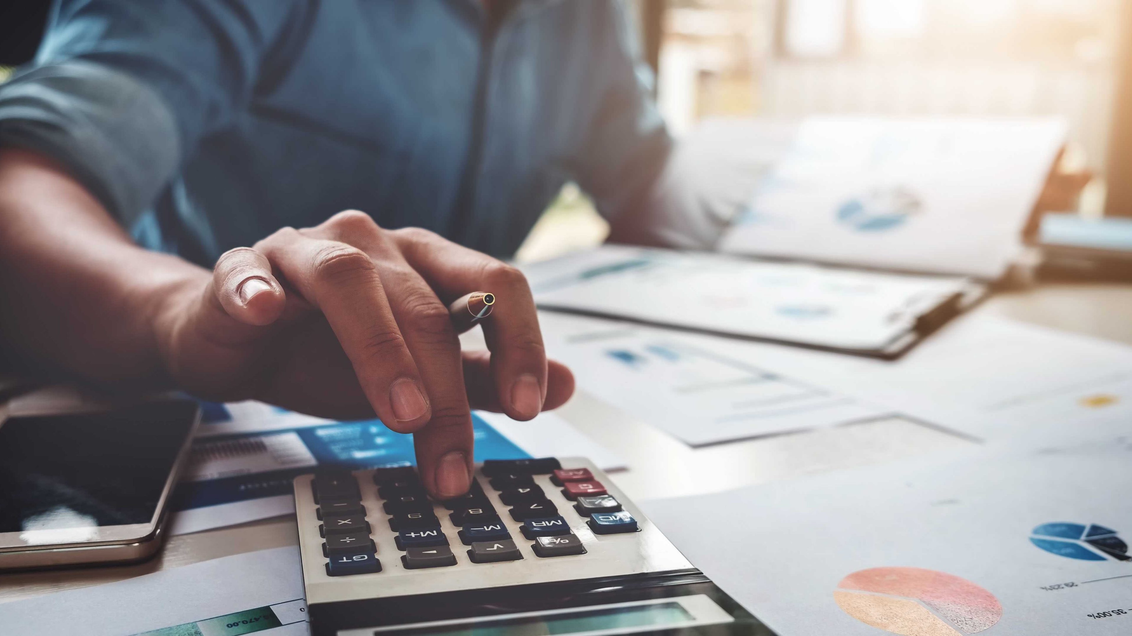 Business accounting concept, Business man using calculator with computer laptop, budget and loan paper in office.